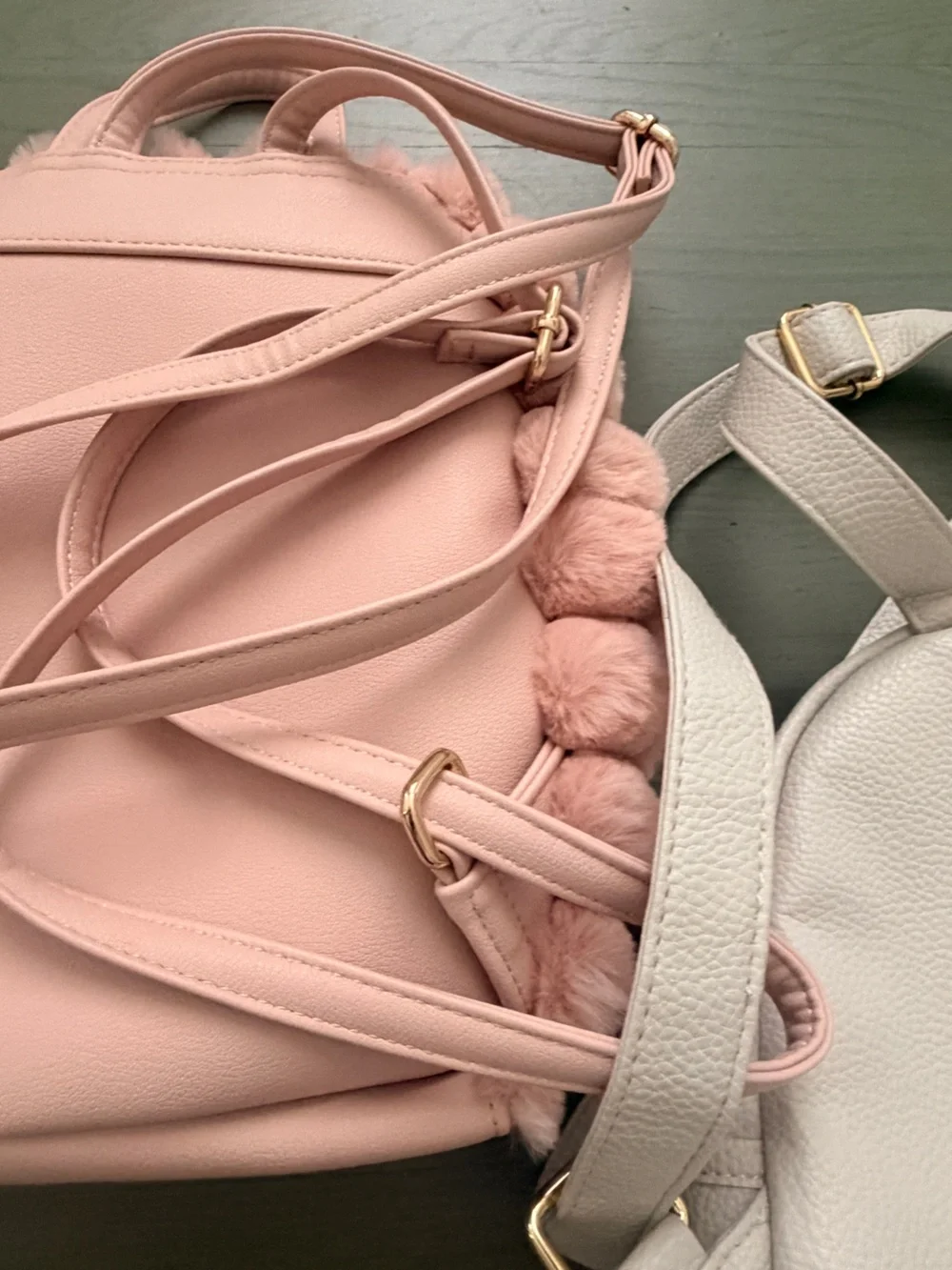 Two cute mini backpacks, one pink fuzzy, one white